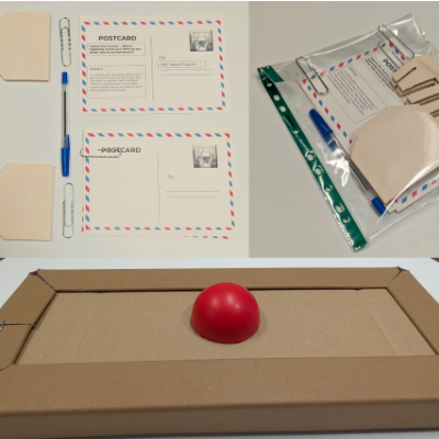 A picture of a workshop pack. There is a box with a button on it and assorted stationary.